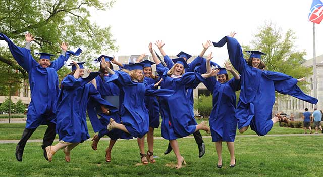 ѿý graduates leap in celebration on the Quad